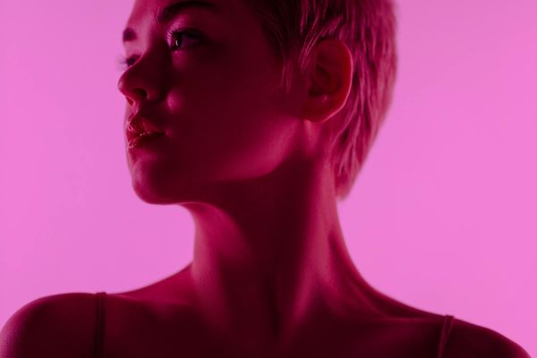 Minimalist yoga studio with soft pink neon lighting.